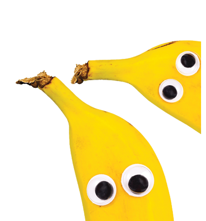 Banner with banana fruits with funny googly eyes on bright blue background with copy space