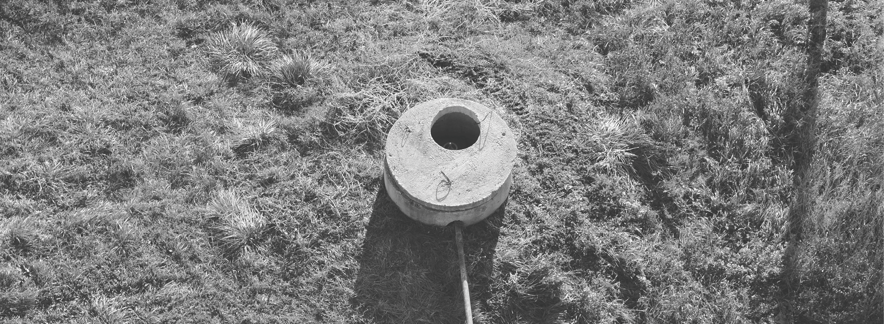 Well of an artesian well with a submersible pump. Covered with a concrete well