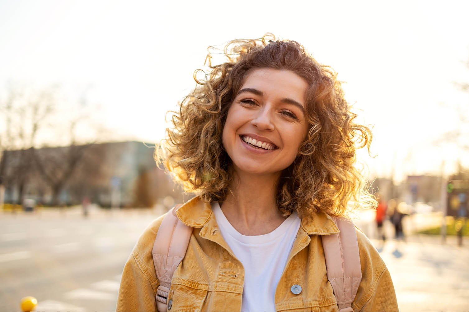 Portrait of young woman with curly hair in the city
